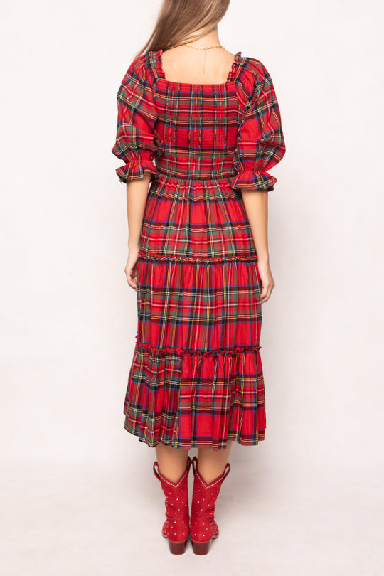 woman in a red plaid dress with red boots on a white background 