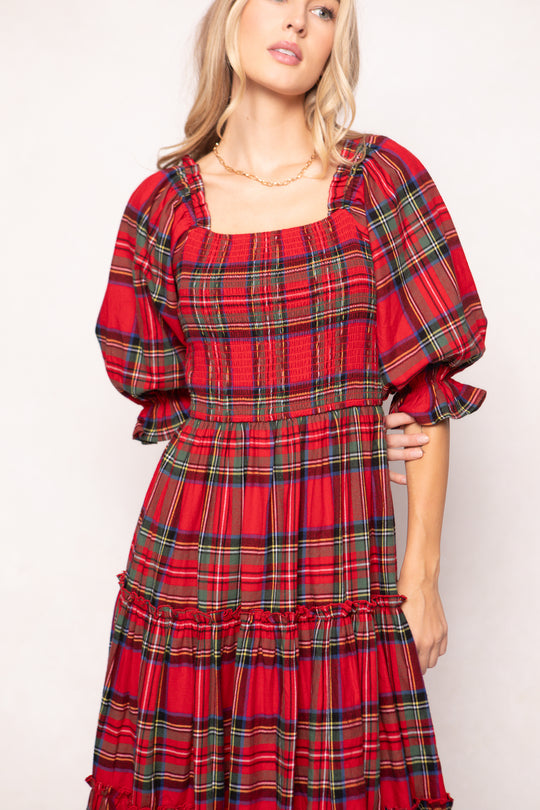 woman in a red plaid dress with red boots on a white background 
