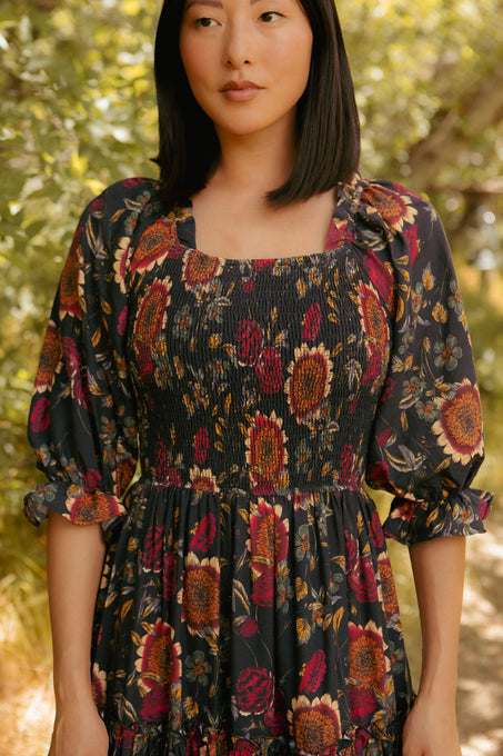 Woman wearing a floral dress standing in a natural setting