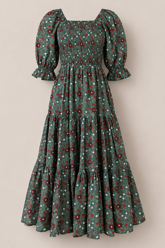 Introducing the Madeline Maxi Dress in Evergreen Merry Ditsy by Ivy City Co—a long, green floral dress featuring a smocked cotton bodice, tiered skirt, and puffed short sleeves. Adorned with small red, white, and blue flowers throughout, this evergreen dress is both maternity and nursing friendly, providing comfort without sacrificing style.