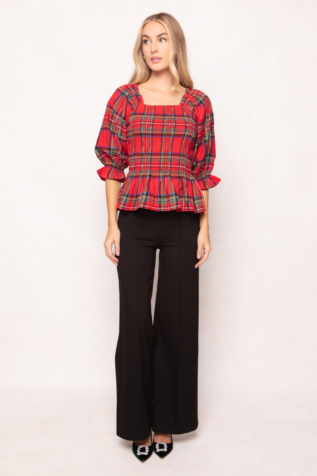 woman wearing a red plaid top on a white background