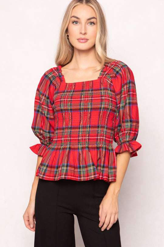 woman wearing a red plaid top on a white background