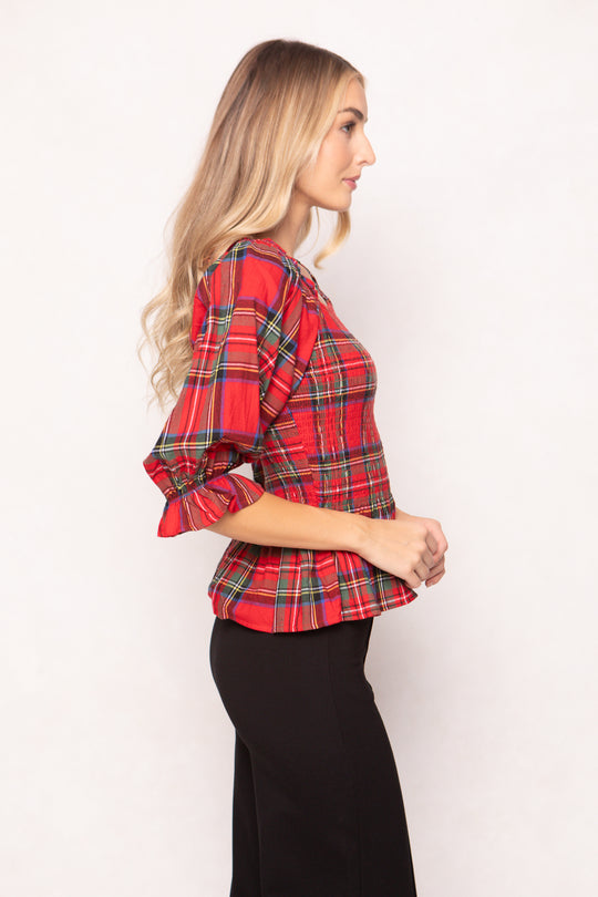 woman wearing a red plaid top on a white background