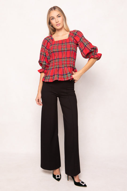 woman wearing a red plaid top on a white background