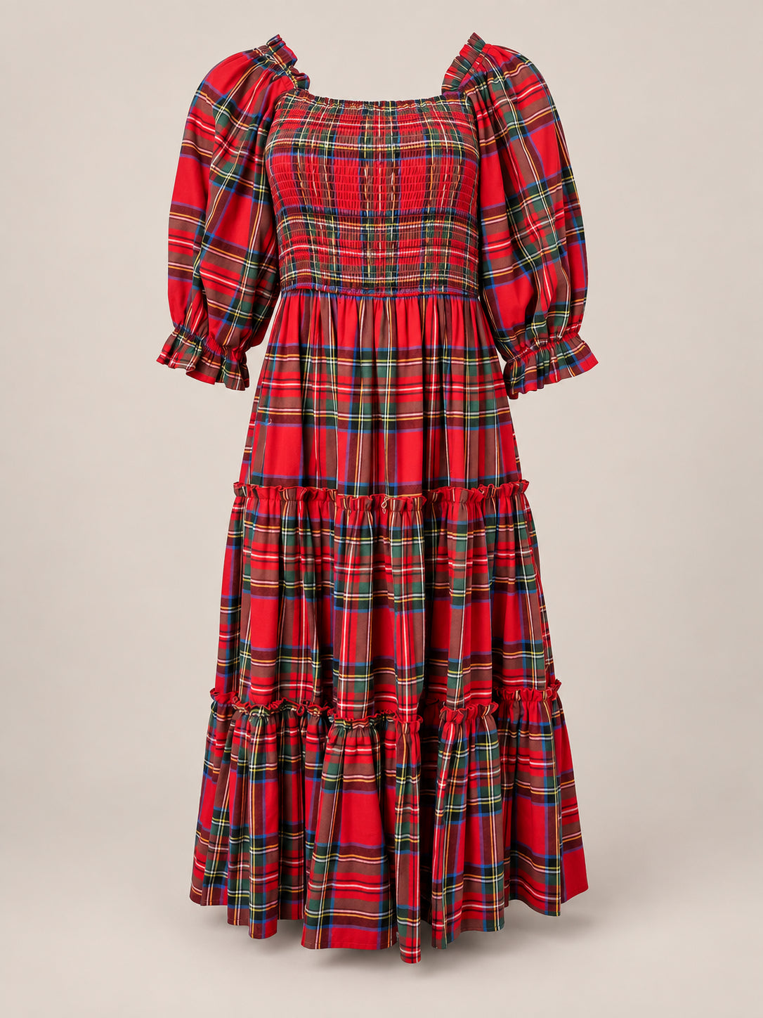 Introducing the Madeline Dress in Holiday Plaid by Ivy City Co—a maternity-friendly style adorned with classic red and green checks. This festive, vintage-inspired dress features a smocked bodice, square neckline, puffed elbow-length sleeves with ruffled cuffs, and a tiered ruffle skirt for added elegance and comfort at every occasion.