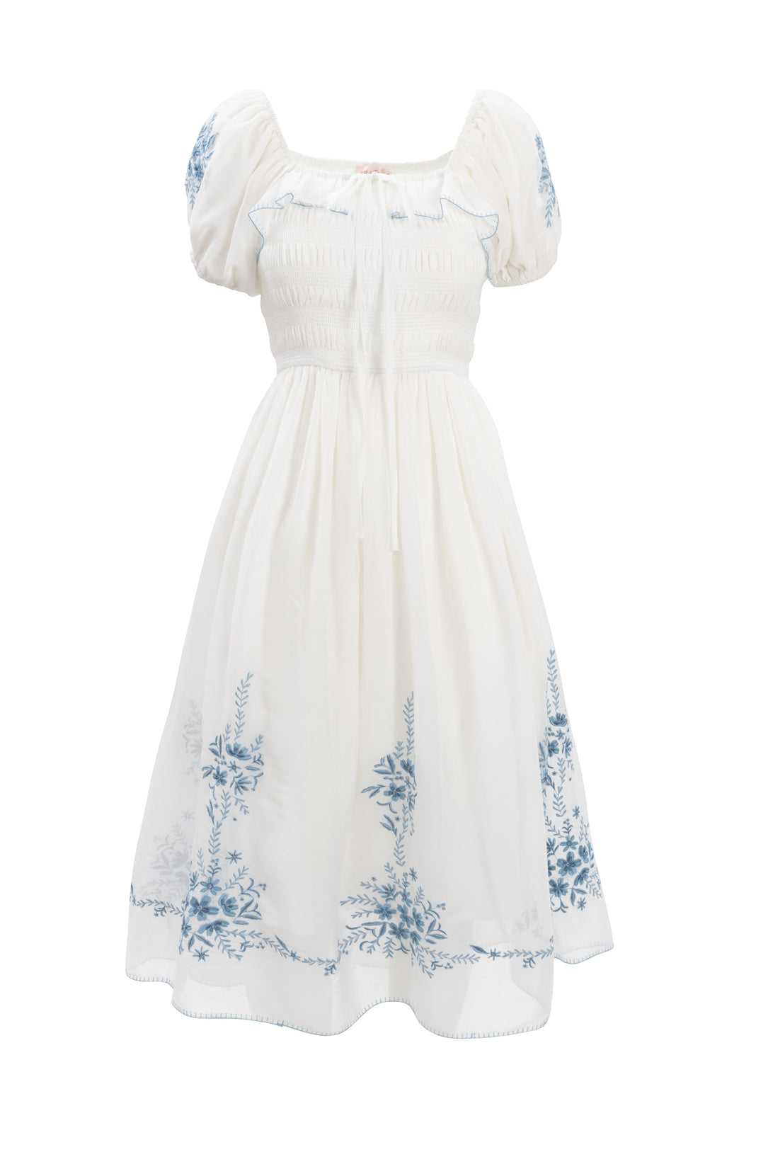 The Mae Dress in White with Blue Floral by Ivy City Co features short puffed sleeves, a fitted ruched bodice, blue floral embroidery, and a soft midi skirt. Its subtle ribbon neckline detail makes it a charming nursing-friendly choice.