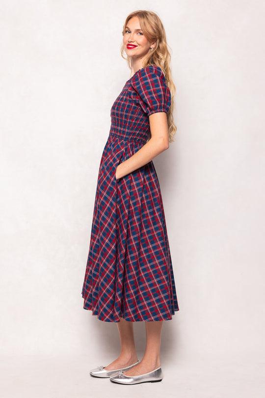 Woman wearing a red and blue checkered dress against a white background