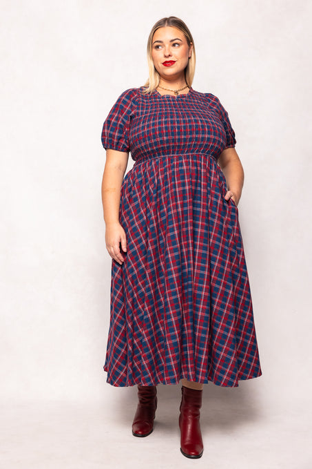 Woman wearing a red and blue plaid dress on a white background