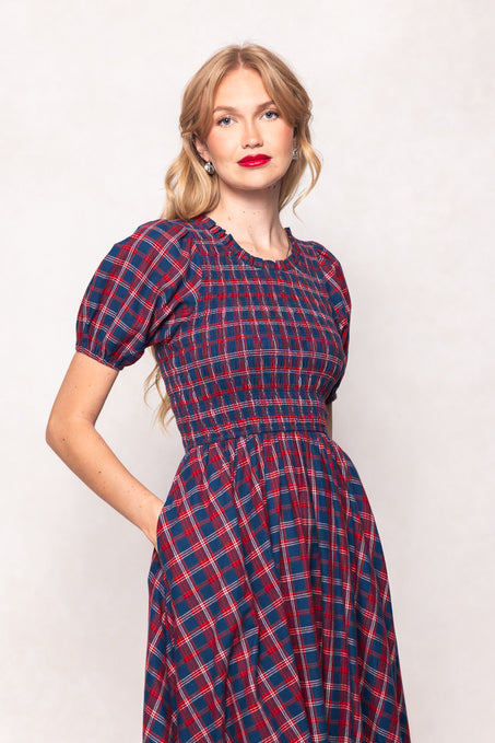 Woman wearing a red and blue plaid dress against a white background