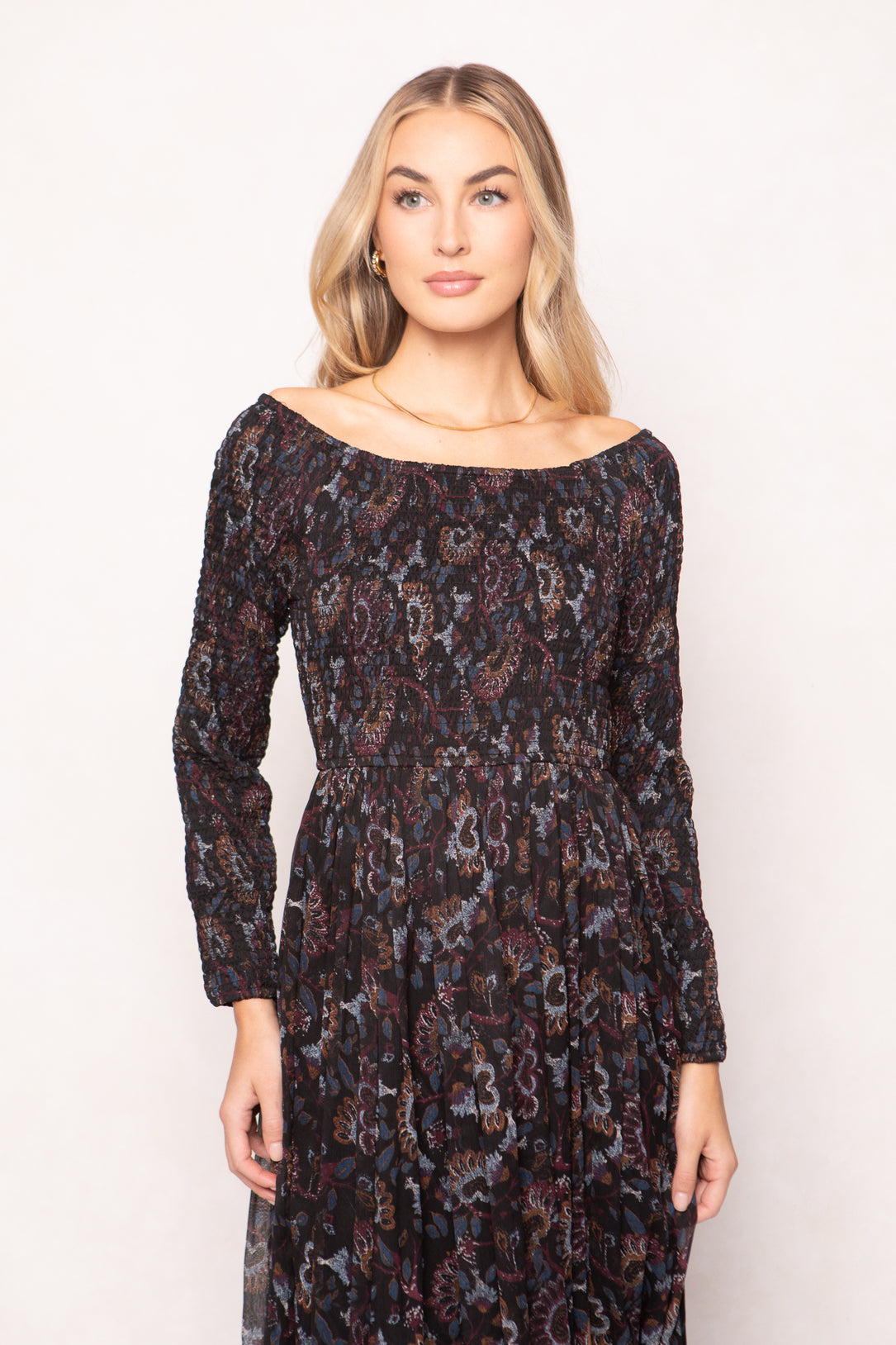 Woman wearing a patterned dress against a plain background