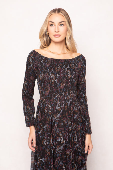 Woman wearing a patterned dress against a plain background