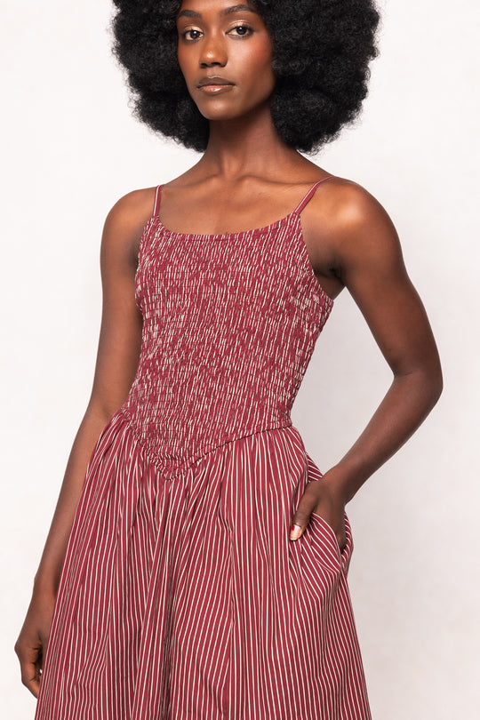Woman wearing a red and white striped dress against a white background