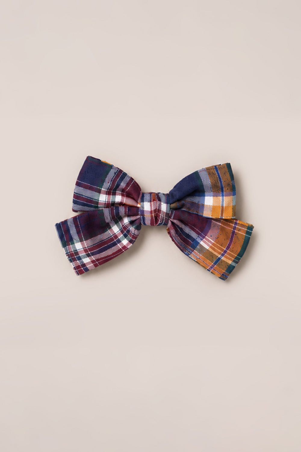 Introducing the Hair Bows in Midnight Plaid by Ivy City Co—crafted from cotton and showcasing a timeless plaid pattern with dark blue, red, white, yellow, and orange stripes. This elegant hair bow is securely fastened to a French barrette clip and photographed against a plain light beige background.