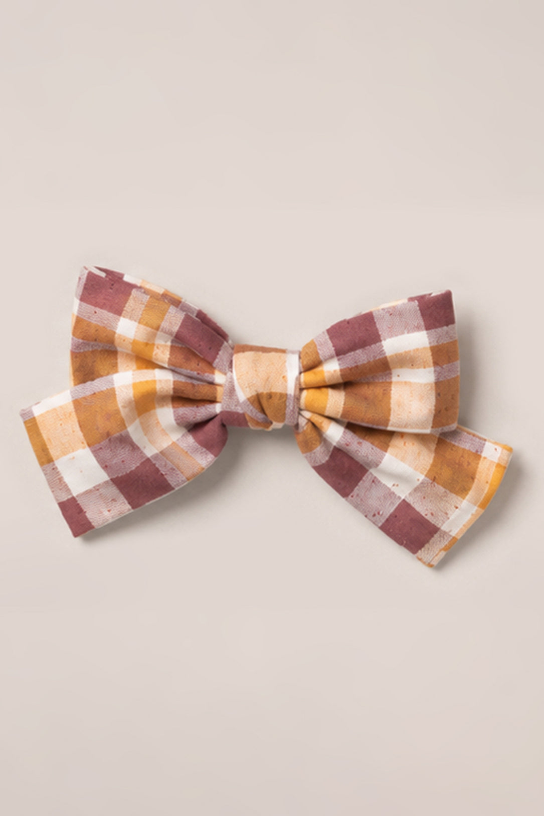 The Hair Bows in Spiced Plaid by Ivy City Co feature a cotton fabric with a spiced plaid pattern in shades of brown, yellow, and white, displayed on a plain light background.