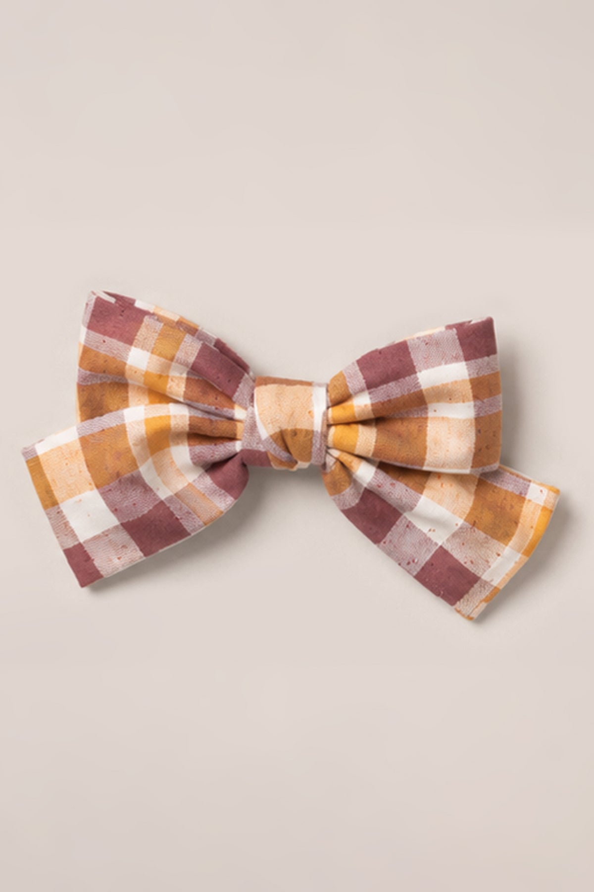 The Hair Bows in Spiced Plaid by Ivy City Co feature a cotton fabric with a spiced plaid pattern in shades of brown, yellow, and white, displayed on a plain light background.