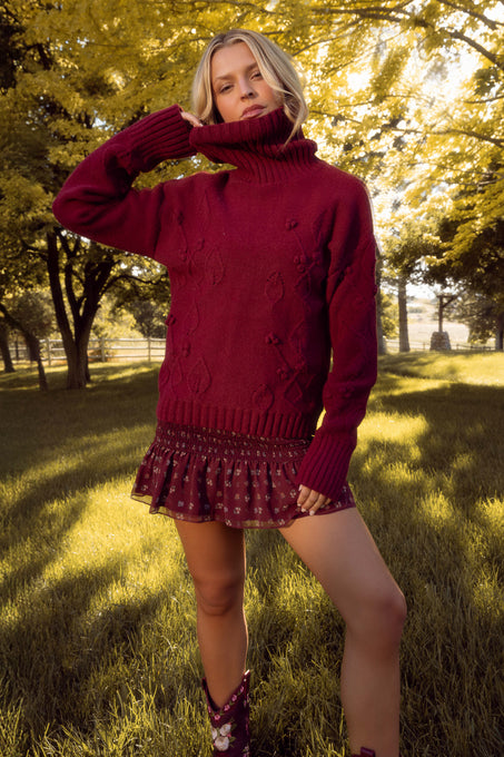 Woman wearing a red sweater and skirt in a park setting