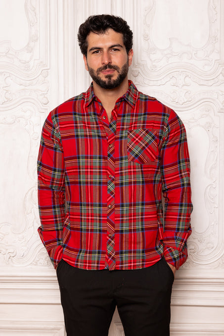 Man wearing a red plaid shirt against a white textured wall