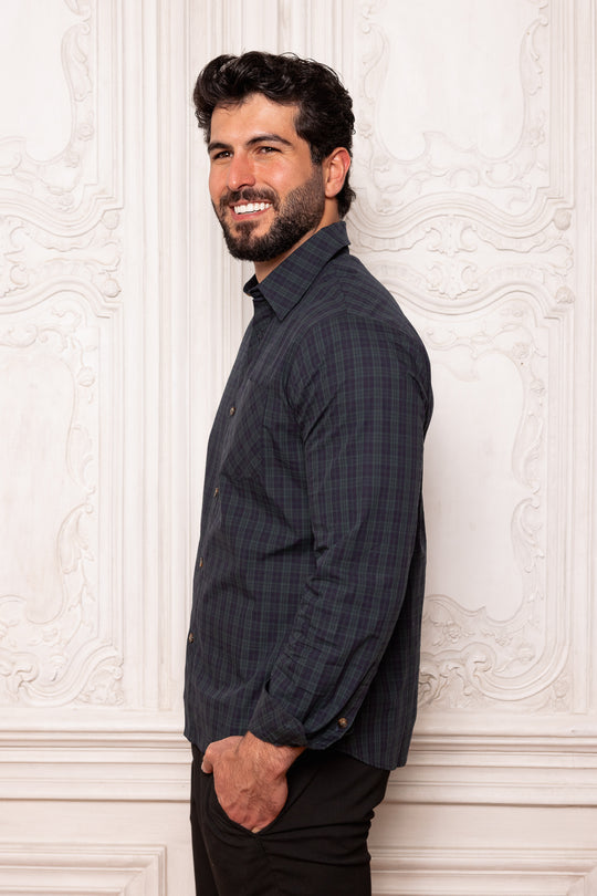 Man wearing a dark blue shirt against a white decorative wall