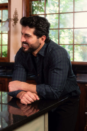 Man leaning on a counter with a window in the background
