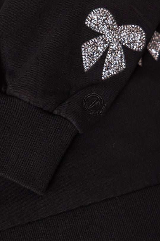 close up image of black fabric and rhinestone bow