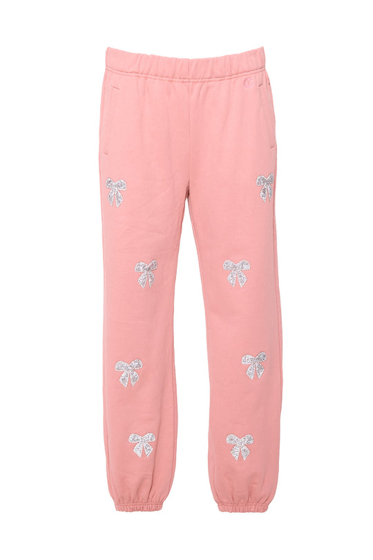 Pink sweatpants with rhinestone bow detail against a white background
