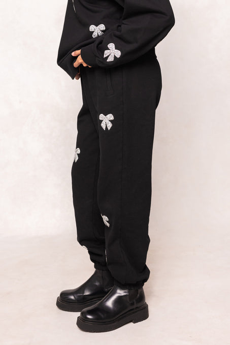 woman in a black sweatsuit against at white background