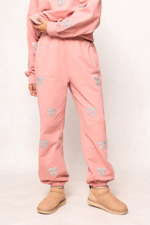 woman in pink sweatsuit against a white background