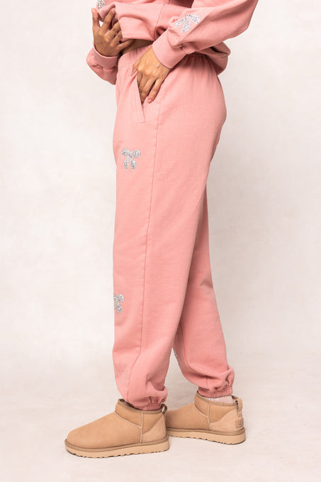 woman in pink sweatsuit against a white background