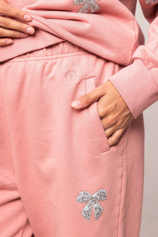 woman in pink sweatsuit against a white background
