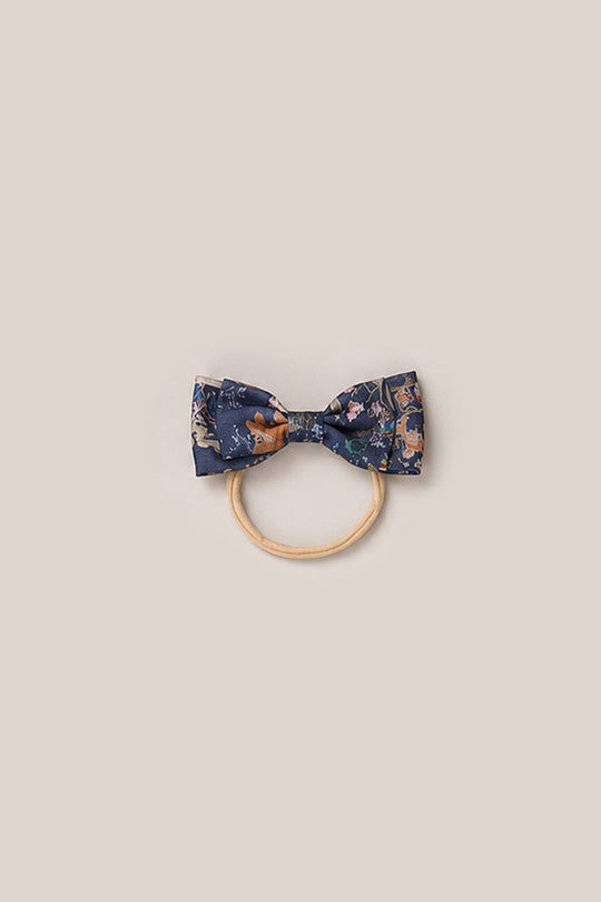A Hair Bow in Midnight Autumn Bouquet from Ivy City Co features navy blue fabric with floral patterns, attached to a simple, light wooden ring. Both items are centered on a plain, light beige background—perfect for adding signature Ivy City Co charm to any look.