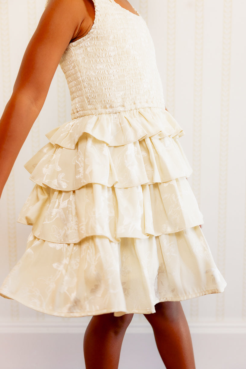 close up of a little girl in a white ruffle dress. 