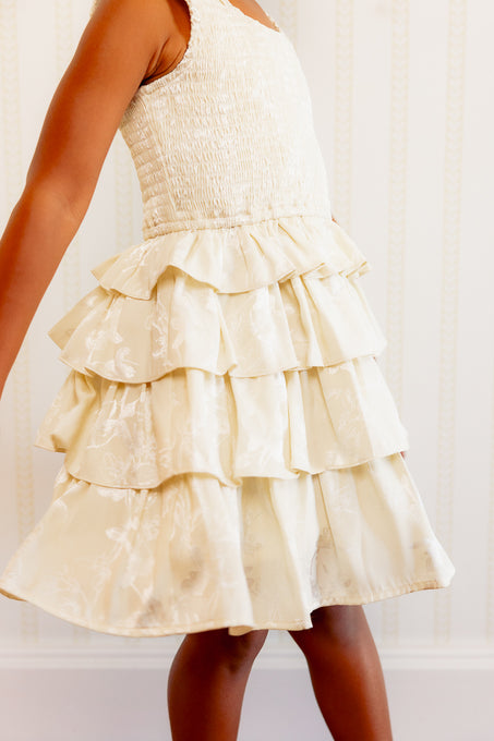 close up of a little girl in a white ruffle dress. 