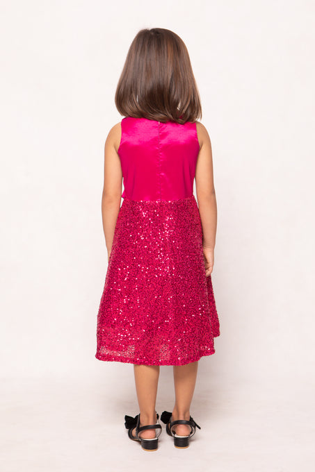 Young girl wearing a pink sequin dress on a white background