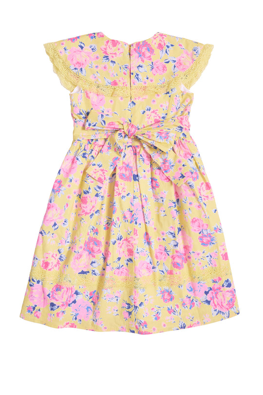 The back of a children's yellow floral dress against a white background