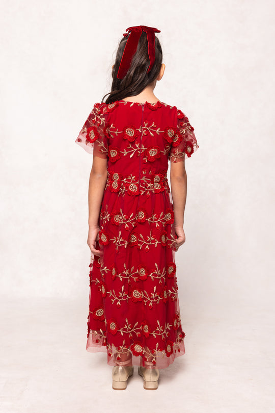 Red embroidered dress worn by a person on a white background