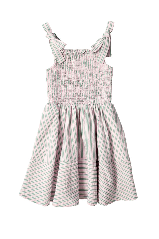 The Mini Bluebell Dress in Green & Pink Pinstripe by Ivy City Co features a sleeveless design, bow-tied shoulder straps, smocked bodice, and a full skirt with playful contrasting diagonal and horizontal stripes.
