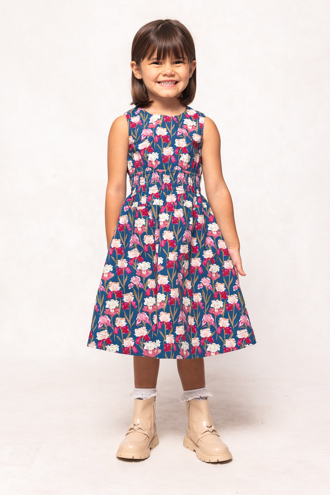 Young girl wearing a floral dress on a white background