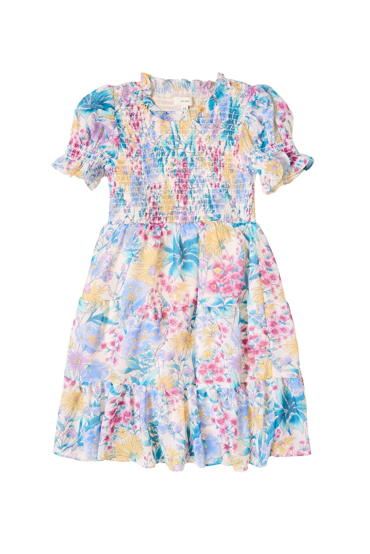 The Mini Cordelia Dress in Pretty Plumeria by Ivy City Co is a short-sleeved, knee-length dress with a vibrant floral pattern, ruched bodice, ruffled collar, and flared skirt. Showcasing pastel blue, pink, yellow, and green hues, it’s perfect for spring celebrations or sweet family moments.