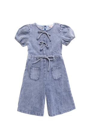 The Mini Dallas Jumpsuit in Denim by Ivy City Co is a stylish girls’ one-piece featuring front lace-up detail, two chest ties, elastic waist with belt, two front pockets, wide-leg shorts, and elastic hem sleeves.
