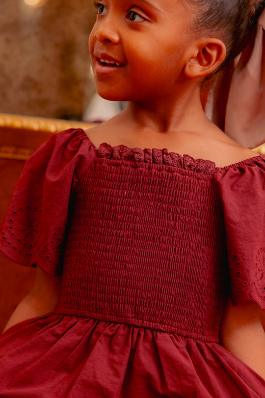 close up of a girl in a burgundy dress 
