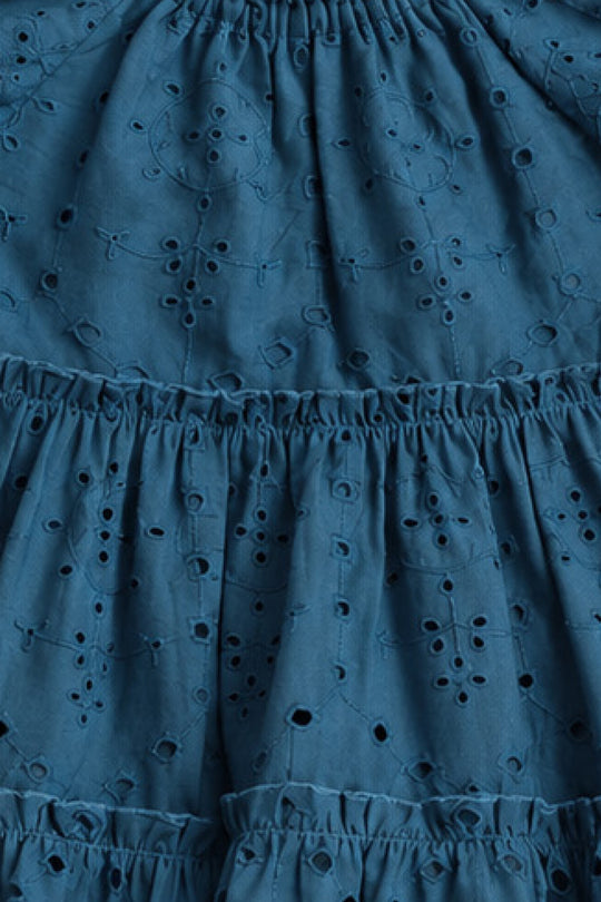 Close-up of blue eyelet embroidery and ruffled, tiered seams on the Mini Etta Dress in Cobalt by Ivy City Co—perfect for a girl's cotton dress or mom and me matching outfits.