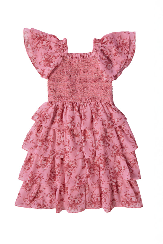 The Mini Grace Dress in Desert Heritage Rose by Ivy City Co features pink floral print, flutter sleeves, a smocked bodice, and a layered ruffle skirt. This girls' dress is shown against a white background.