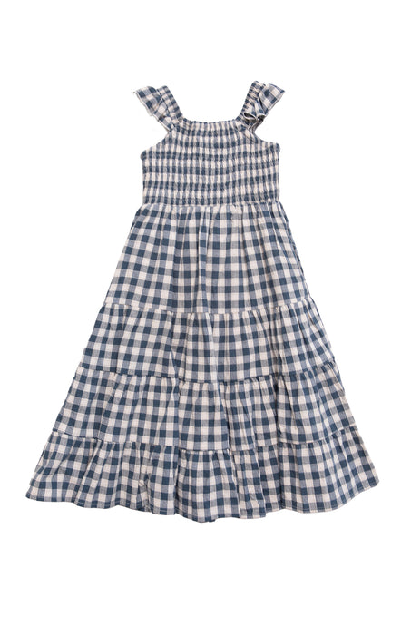 The Mini Hailey Dress in Indigo Gingham by Ivy City Co is a sleeveless cotton girls midi dress with blue and white checks, ruffled shoulder straps, smocked bodice, and a tiered ankle-length skirt for all-day comfort.
