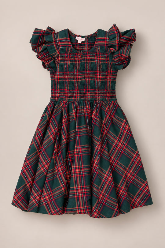 The Mini Hattie Dress in Evergreen Plaid by Ivy City Co, a children’s dress made from soft cotton with short ruffled sleeves, a smocked bodice, and a flared skirt, is displayed on a neutral background.