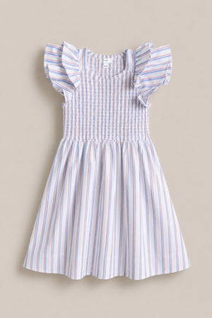 The Mini Hattie Dress in Heritage Stripe by Ivy City Co is a sleeveless dress with ruffled shoulders, smocked bodice, and flared skirt in red, blue, and pink stripes—ideal for July 4th or Mom & Me matching. Shown on a neutral surface.
