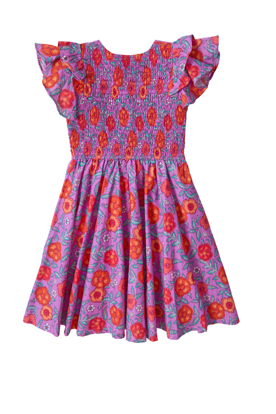 The Mini Hattie Dress in Thistle Flower Poppy Woodblock by Ivy City Co is a girls' cotton midi dress with short ruffled sleeves, a smocked bodice, and a vibrant orange, red, and pink floral print on purple.