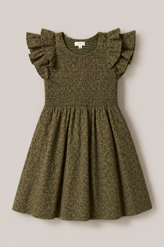 The Mini Hattie Dress in Woodland Floral by Ivy City Co is an olive green, short-sleeve cotton dress for girls showcasing a delicate small floral print, a smocked bodice, and charming ruffled sleeves. Its gathered skirt flares out beautifully. The dress is displayed laid flat on a light beige background.