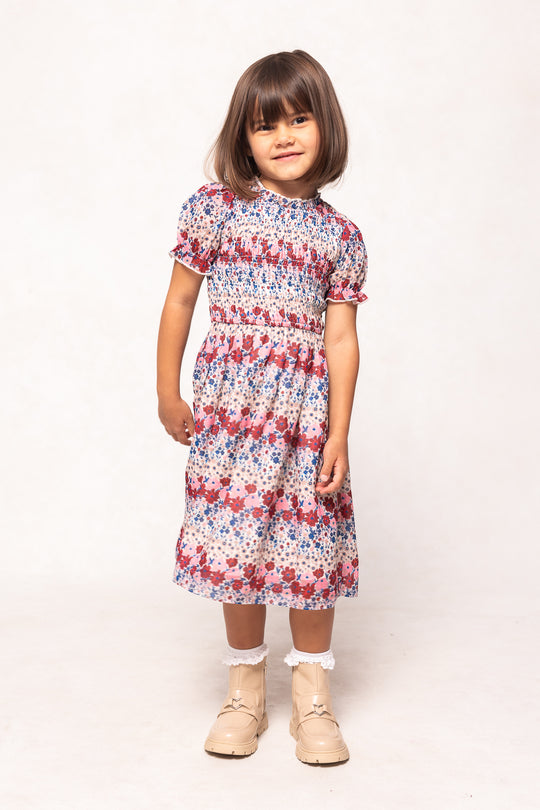 Young girl wearing a floral dress on a white background