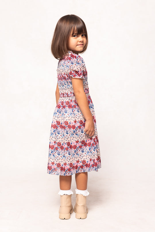 Young girl wearing a floral dress on a white background