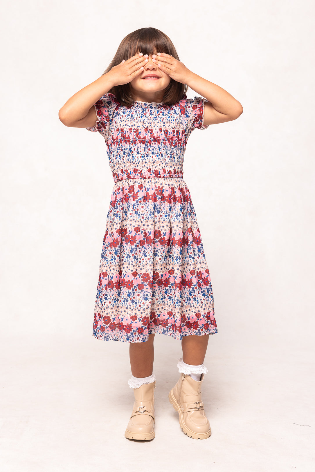 Young girl wearing a patterned dress on a white background